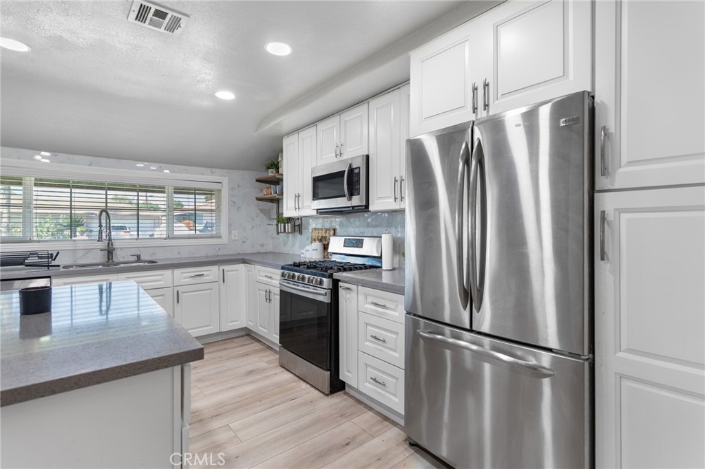 1005 North Encina Avenue Rialto, CA 92376 - Photo 12 of 39 a kitchen with stainless steel appliances a refrigerator sink and microwave