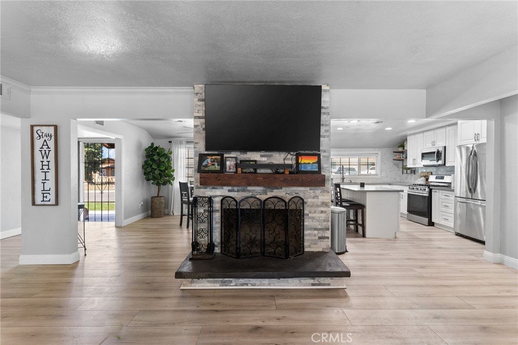 1005 North Encina Avenue Rialto, CA 92376 - Photo 16 of 39 a living room with furniture a fireplace and a flat screen tv