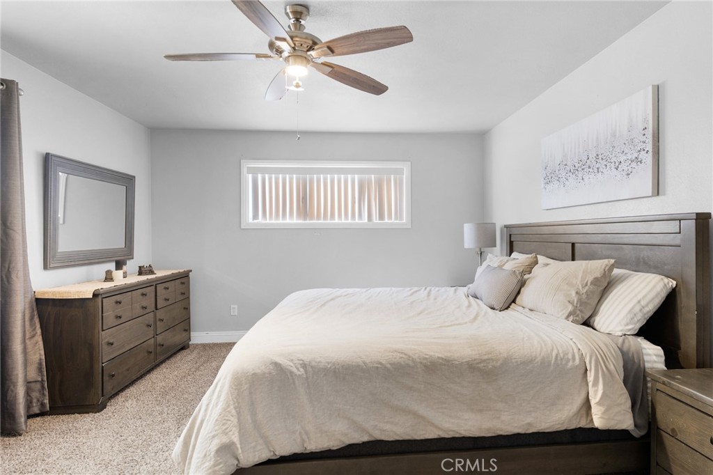 1005 North Encina Avenue Rialto, CA 92376 - Photo 20 of 39 a bedroom with a large bed and a chandelier