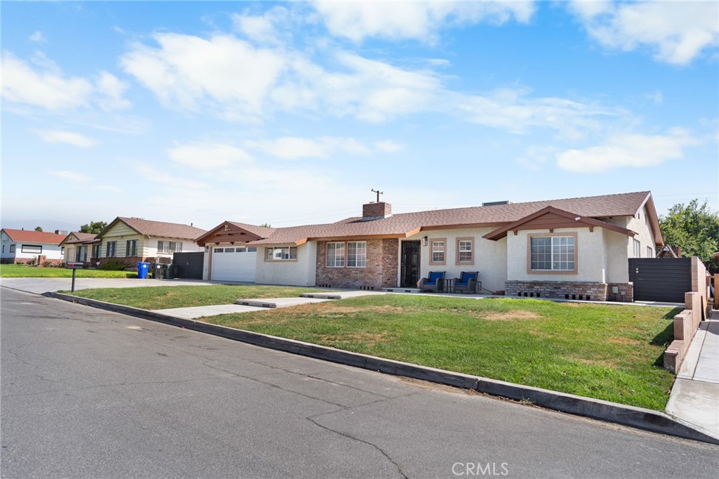1005 North Encina Avenue Rialto, CA 92376 - Photo 2 of 39 a view of a house with a big yard and large trees