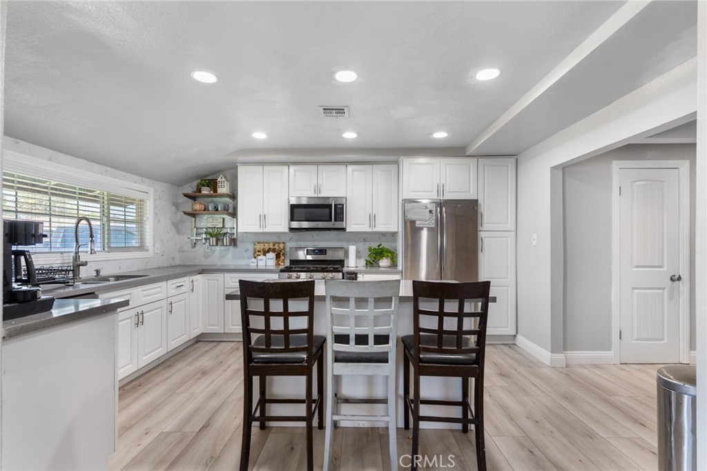 1005 North Encina Avenue Rialto, CA 92376 - Photo 9 of 39 a kitchen with stainless steel appliances kitchen island granite countertop a refrigerator and microwave
