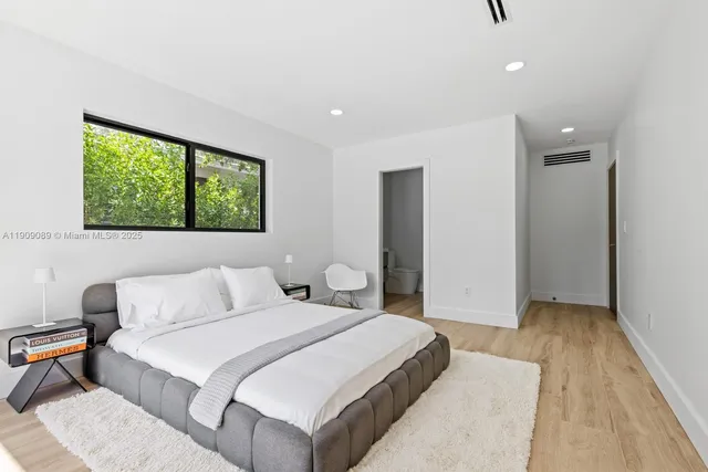 a bedroom with a bed and a large window