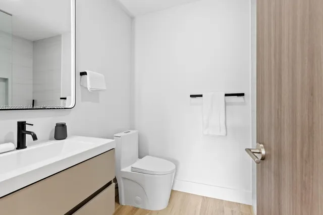 a bathroom with a toilet a sink and mirror