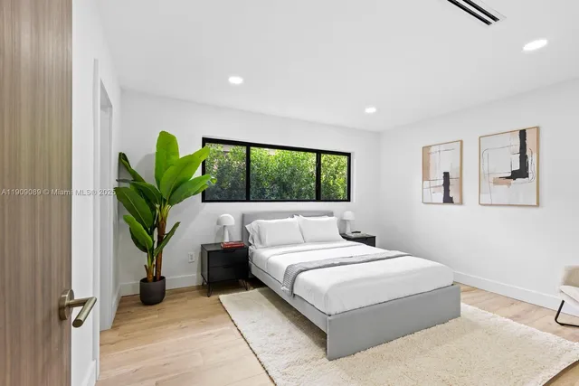 a bedroom with a large bed and a potted plant