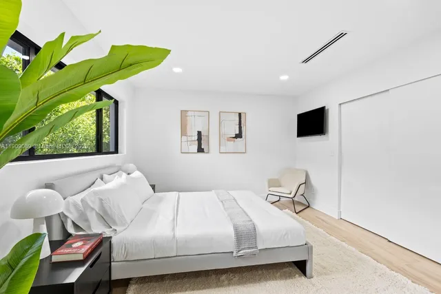 a bedroom with a bed and a flat tv screen