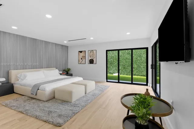 a spacious bedroom with a bed and a flat screen tv