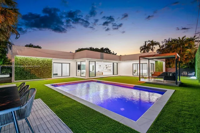 a view of a house with pool and chairs
