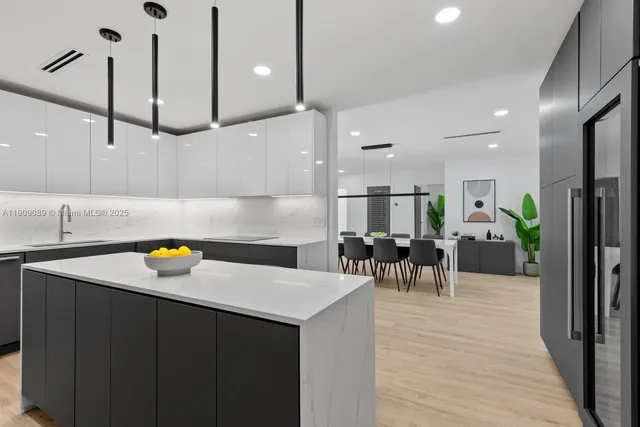 a kitchen with a sink a counter space appliances and cabinets