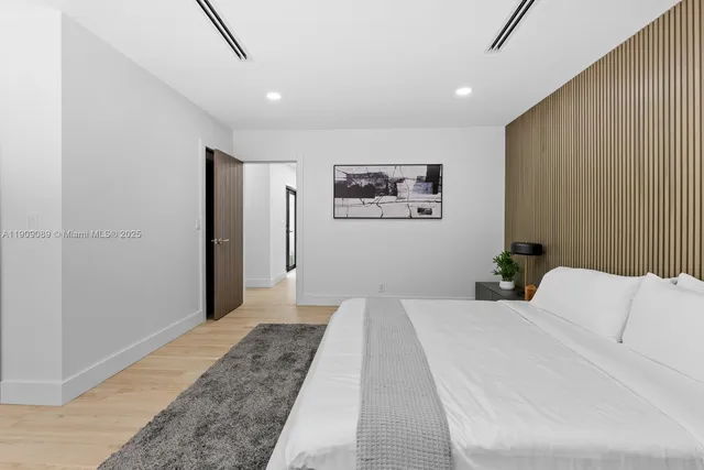 a bedroom with a bed and a painting on the wall