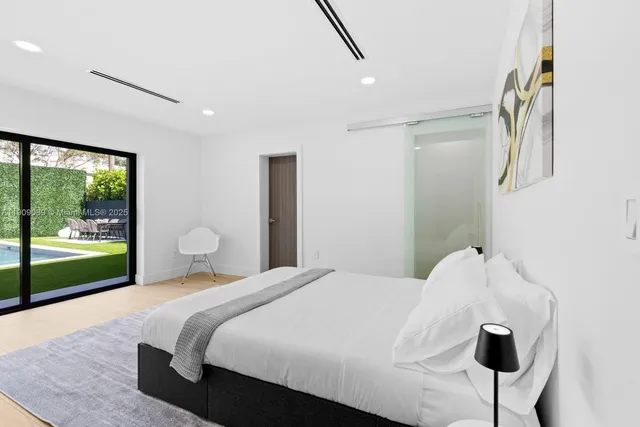 a bedroom with a bed and a large window