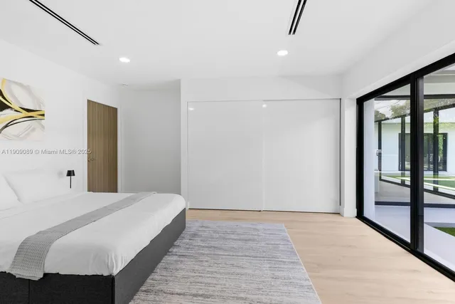 a bedroom with a large bed and a large window