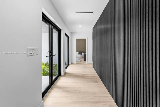 a hallway with wooden floor windows