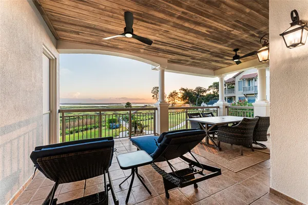 a view of a balcony with furniture and floor to ceiling window