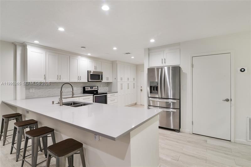 307 Bonnie Brae Way, Unit 26 Hollywood, FL 33021 - Photo 1 of 21 a kitchen with a refrigerator a stove a sink and chairs
