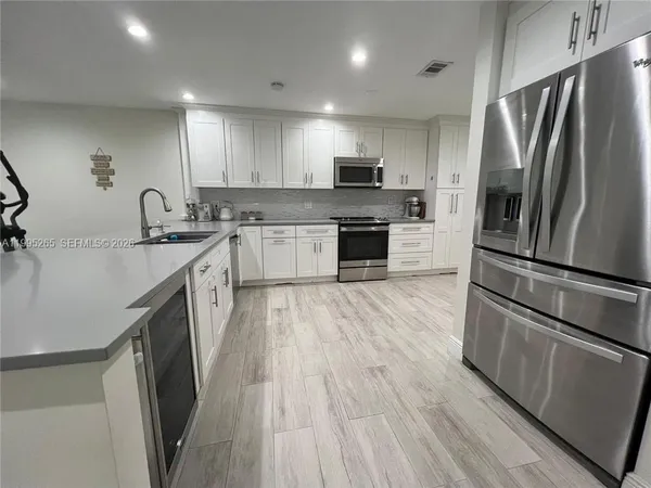a kitchen with stainless steel appliances a refrigerator sink and microwave