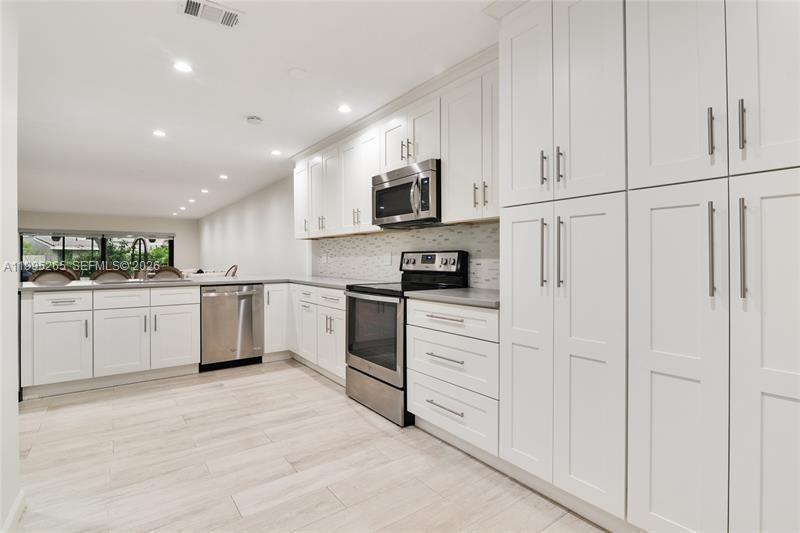 307 Bonnie Brae Way, Unit 26 Hollywood, FL 33021 - Photo 3 of 21 a kitchen with white cabinets and white appliances