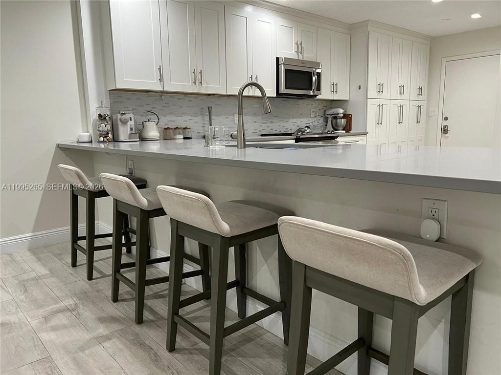 307 Bonnie Brae Way, Unit 26 Hollywood, FL 33021 - Photo 5 of 21 a kitchen with stainless steel appliances granite countertop a table chairs microwave and sink