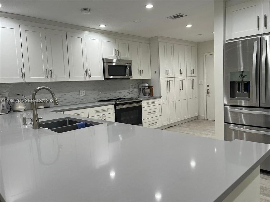 307 Bonnie Brae Way, Unit 26 Hollywood, FL 33021 - Photo 6 of 21 a kitchen with stainless steel appliances a refrigerator sink and microwave
