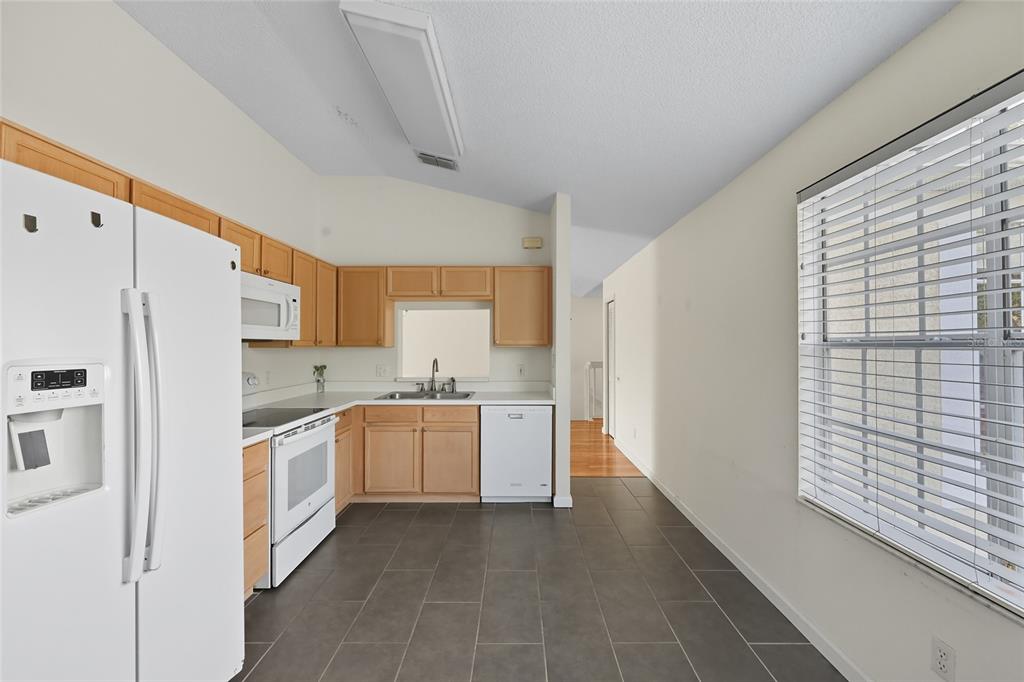 6029 Lake Pointe Drive, Unit 202 Orlando, FL 32822 - Photo 11 of 28 a kitchen with a refrigerator a stove top oven a sink and dishwasher