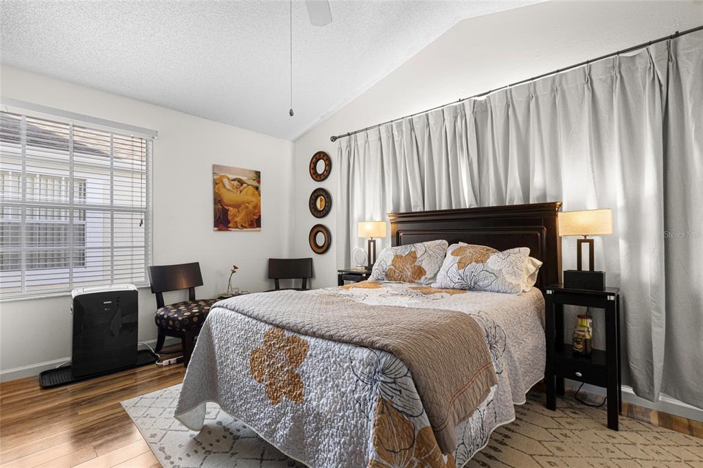 6029 Lake Pointe Drive, Unit 202 Orlando, FL 32822 - Photo 13 of 28 a bedroom with a bed and wooden floor