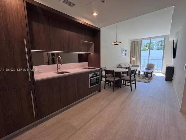 a dining hall with stainless steel appliances wooden floors a table and chairs