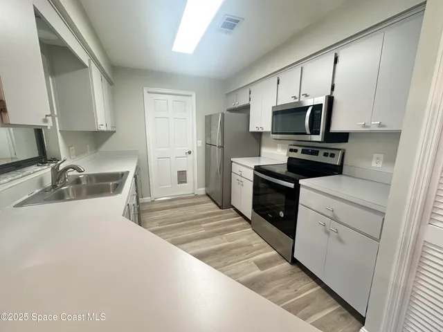 a kitchen with stainless steel appliances a stove sink microwave and cabinets