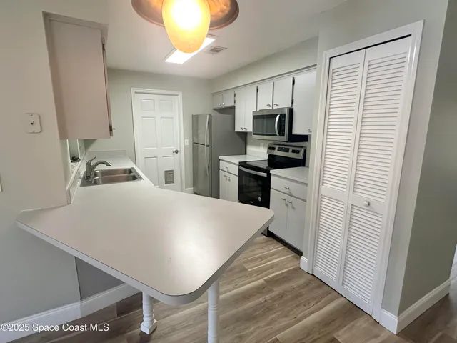 a kitchen with kitchen island a sink appliances and cabinets