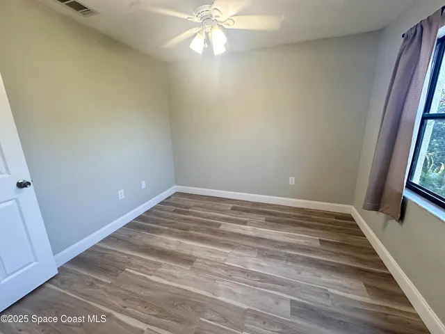 a view of a room with wooden floor and fan