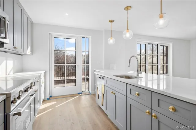 a kitchen with white cabinets appliances and sink