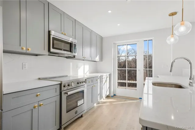 a kitchen with stainless steel appliances granite countertop a stove a sink and a microwave