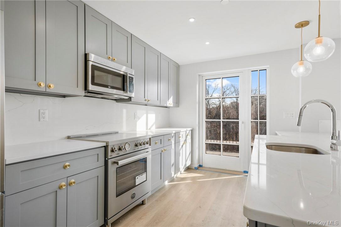 139 Fifth Avenue, Unit 5C Pelham, NY 10803 - Photo 13 of 32 a kitchen with white cabinets appliances and sink