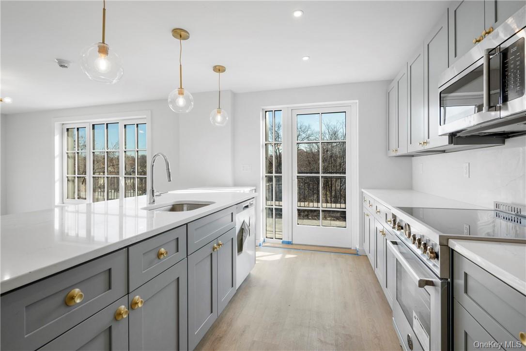 139 Fifth Avenue, Unit 5C Pelham, NY 10803 - Photo 15 of 32 a kitchen with a sink stove and cabinets