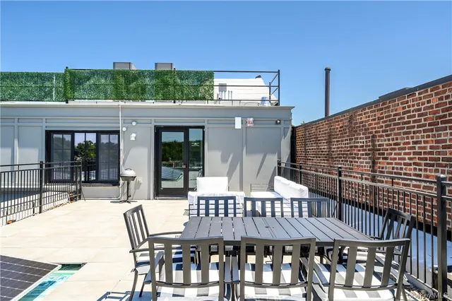 a patio with glass top table and chairs