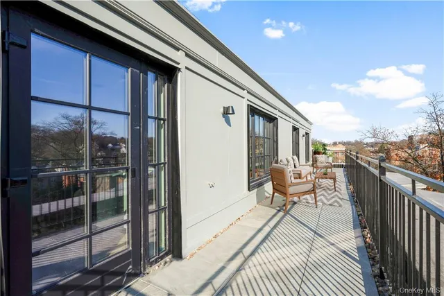 a balcony with wooden floor and outdoor seating