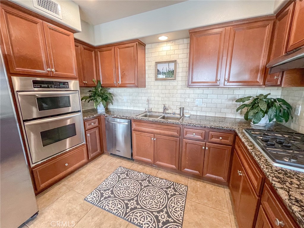 4240 Tradewinds Drive Oxnard, CA 93035 - Photo 19 of 43 a kitchen with granite countertop a sink cabinets stainless steel appliances and a counter space