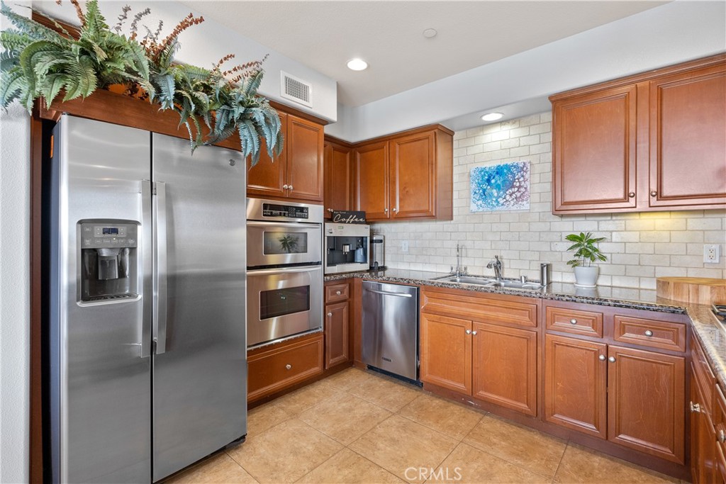 4240 Tradewinds Drive Oxnard, CA 93035 - Photo 20 of 43 a kitchen with stainless steel appliances granite countertop a refrigerator and a sink