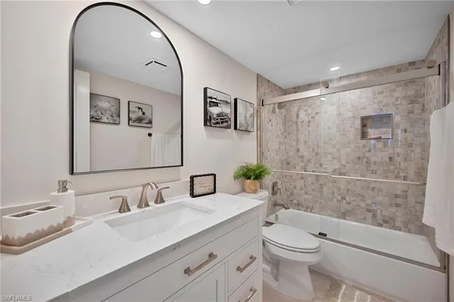 a bathroom with a granite countertop sink a toilet and shower
