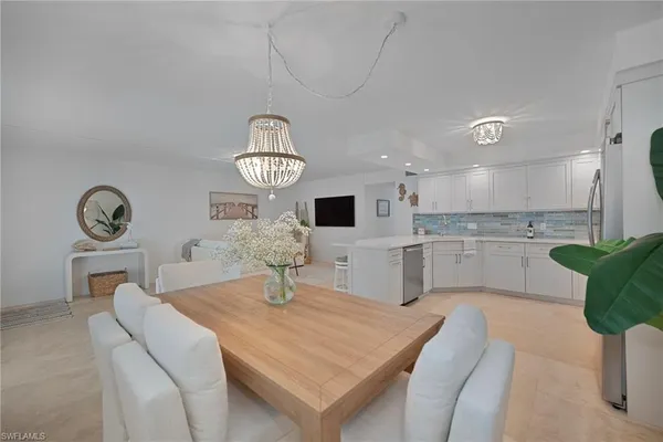 a kitchen with a table chairs and a refrigerator