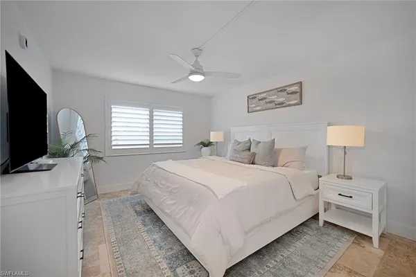 a bedroom with bed tv and window