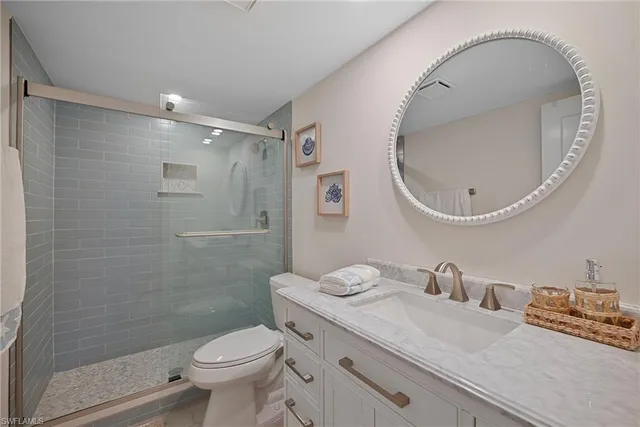 a bathroom with a granite countertop toilet a sink and a mirror