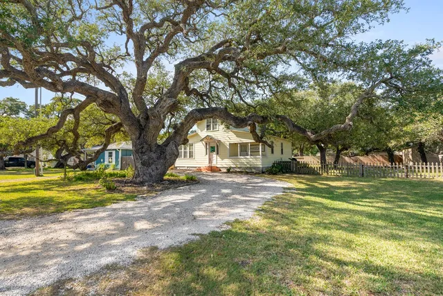 a view of a house with a yard and a trees