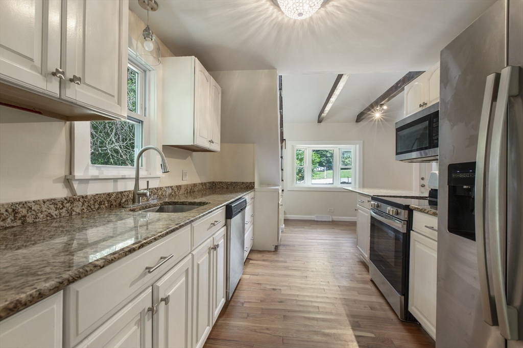 68 Birch Hill Road Douglas, MA 01516 - Photo 12 of 40 a kitchen with stainless steel appliances granite countertop a sink a stove top oven a refrigerator cabinets and a kitchen island