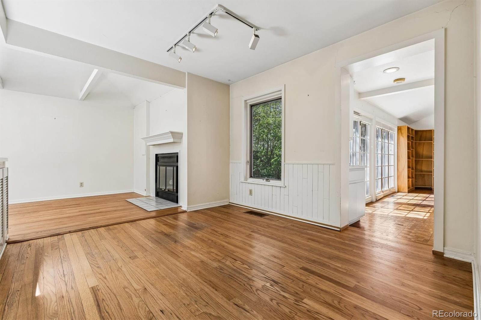 815 Oneida Street Denver, CO 80220 - Photo 18 of 39 a view of an empty room with wooden floor fireplace and a window
