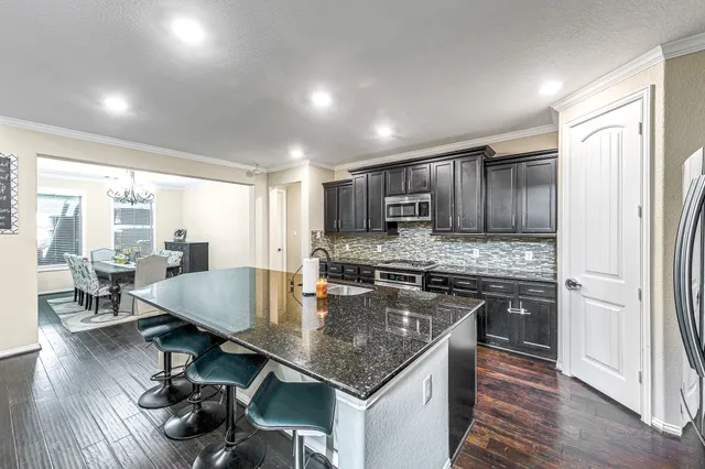 a kitchen with stainless steel appliances granite countertop a stove refrigerator and cabinets