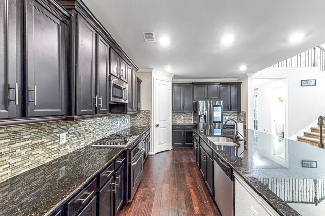 a kitchen with stainless steel appliances granite countertop counter space a stove and cabinets