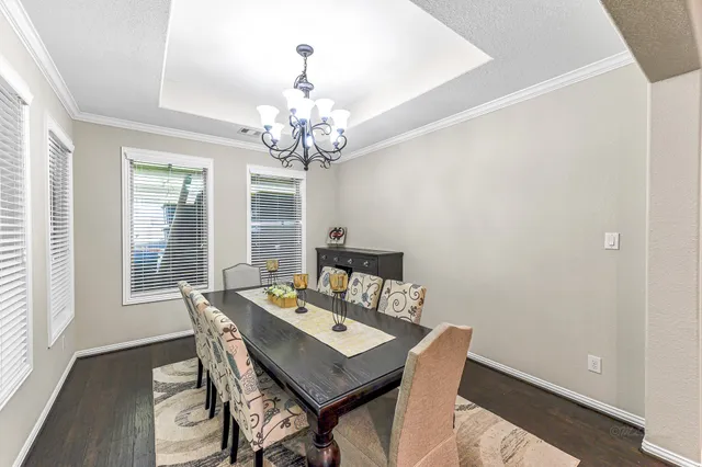 a view of a dining room with furniture a chandelier and wooden floor