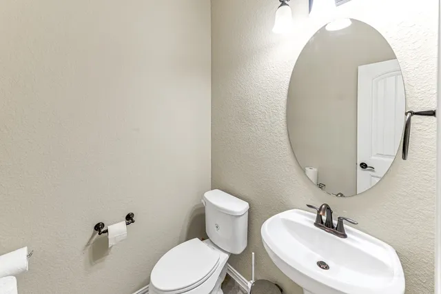 a bathroom with a toilet sink and mirror
