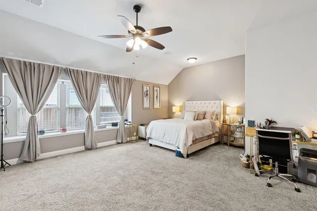 a spacious bedroom with a bed a chandelier and a window