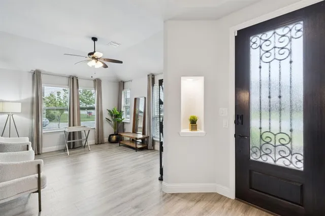 a view of a livingroom with furniture a floor to ceiling window and wooden floor