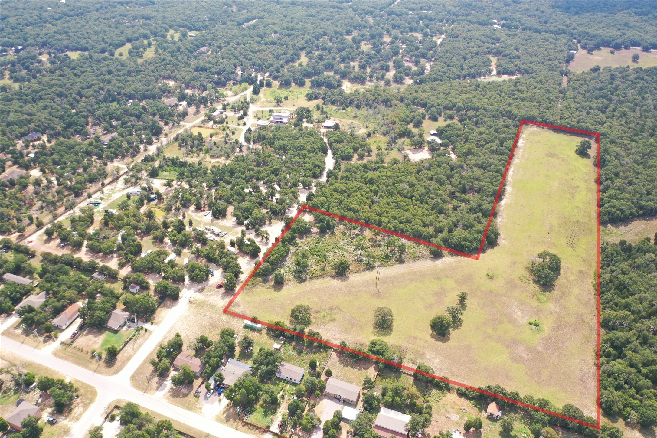 446 Las Lomas Drive Elgin, TX 78621 - Photo 7 of 9 Aerial view of property and surrounding area featuring a forest and property boundaries highlighted